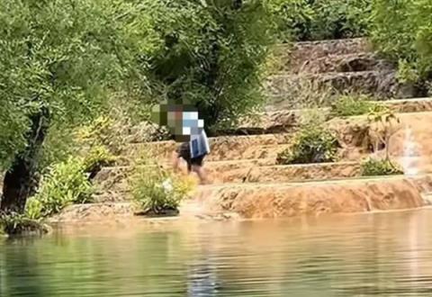 游客在四川黄龙景区钙华池内洗澡 景区：实为捡无人机(图1)