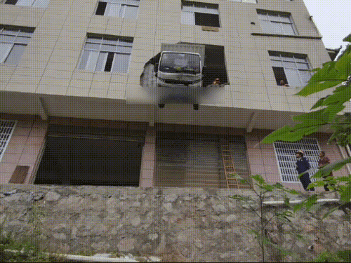 堪比特效大片 货车从大楼穿墙而出 车头悬至15米半空(图2)